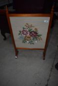 A traditional stained frame fire screen having woolwork insert
