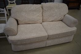 A modern cream two seater sofa bed