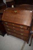 A Georgian oak bureau having fitted interior, brass handles , four drawers and bracket feet, nice
