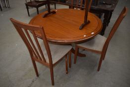 A modern teak effect circular top dining table and set of three railback dining chairs