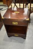 A reproduction mahogany bedside or similar cabinet with campaign style brass edging, drawer to top