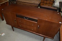 A vintage sapele sideboard having four central drawers flanked by cupboards , on tapered legs, width