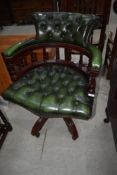 A modern green leather office armchair on swivel base