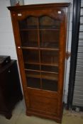 An early 20th Century walnut narrow display cabinet having cupboard below, height approx. 164cm,