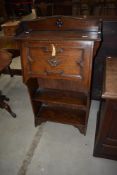 A dark oak Arts and Crafts bureau with bookshelf under