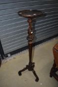 An early 20th Century mahogany torchere plant stand on tapered column with triple splay legs, height