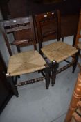 A pair of Victorian stained frame rail back kitchen chairs with later strung seats