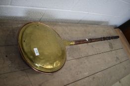 A traditional brass and copper warming pan