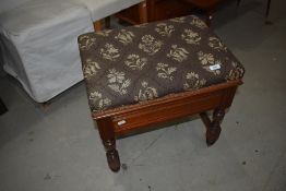 A modern piano stool having carved and turned Mahogany frame with seat storage.