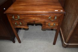 A George III mahogany lowboy having one long and two short drawers with shaped apron and square