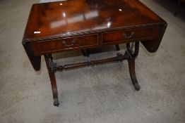 A reproduction mahogany sofa table, of traditional design with lyre form ends linked by a turned