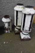 A pair of traditional painted tall chimney pots and a similar top part