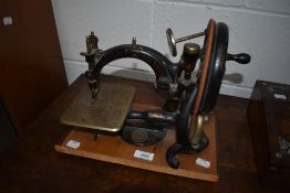 A Victorian handcrank sewing machine of stylised form by Willcox and Gibbs Sewing Machine Co, on