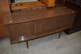 A retro mid century American walnut effect formica sideboard, of slightly bow-fronted oblong form,
