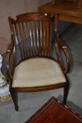 An Edwardian mahogany salon armchair having inlaid decoration to rail back , on tapered legs with