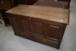 A period oak coffer having panels over two base drawers, dimensions approx. W141 D55 H80cm