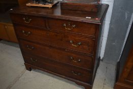 A Georgian rustic mahogany chest of two over three drawers, having brass drop handles, on bracket