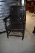 An antique vernacular Wainscott style chair in oak with panel back and seat having later