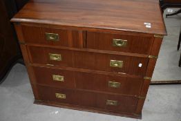 A reproduction campaign style chest having three drawers plus one faux drawer having drop flap,