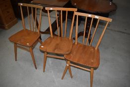 A set of three Ercol kicthen chairs having spindle backs