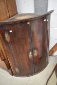A 19th Century oak bow fronted corner cupboard