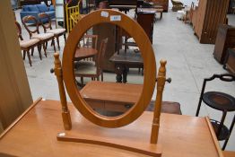 A modern pine effect oval dressing table mirror