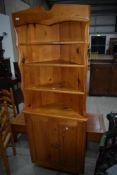A vintage yellow pine corner shelf with cupboard under