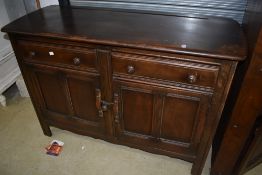 A dark stained Ercol sideboard, along with an Ercol double corner cupboard, the sideboard without