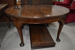 An early 20th Century mahogany oval dining table having wind out extensions with two further leaves,