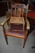 An early 20th century oak carver chair, sold together with a strung footstool