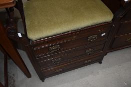 A late Victorian piano stool having seat storage and double under drawers with turned twin handles.