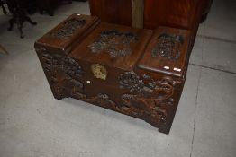 A traditional Oriental bedding box having typical carved and decoration and brass clasp, approx