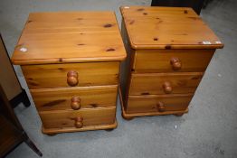 A pair of pine three drawer bedside chests