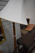 A traditional stained frame standard lamp having carved decoration to base and column