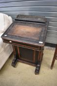 A 19th Century ebonised davenport having walnut inlay, in need of restoration