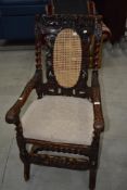 A 19th century carved armchair with armorial design and restored canework back