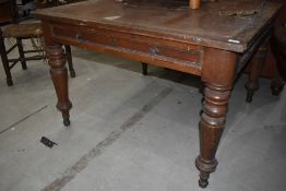 A Victorian oak library style table or desk having frieze drawer and inset leather top, on turned