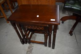 A reproduction oak nest of three occasional tables