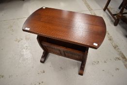 A reproduction oak magazine table, with linen fold decoration to lower