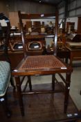 A Victorian oak bedroom chair having cane seat