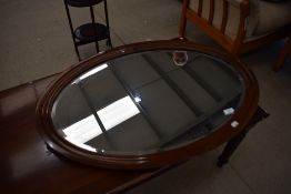 An early 20th Century mahogany oval wall mirror of plain form, diameter approx. 85cm