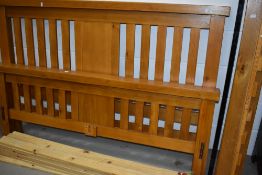 A modern golden oak bed frame having slatted 5ft width base