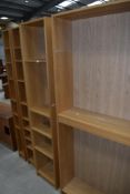 A selection of laminate tall bookshelves and similar narrow display shelves
