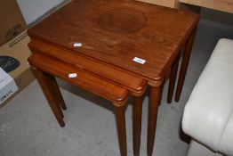 A vintage teak nest of three tables