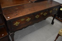 An 18th Centuey Vernacular oak dresser base, having heavy brass hanldes, width approx. 162cm