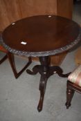A 19th Century mahogany tripod table having circular top with carved edge and legs, on turned