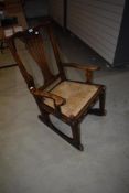 A farm house style rocking chair having oak frame with woven fibre seat