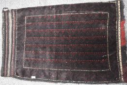A traditional rug in red and black hues.