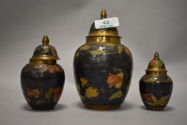 Three 20th century brass lidded urns with enamelled decoration.