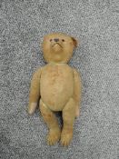 An early/mid 20th century straw filled Steiff style hump back yellow mohair jointed Teddy Bear